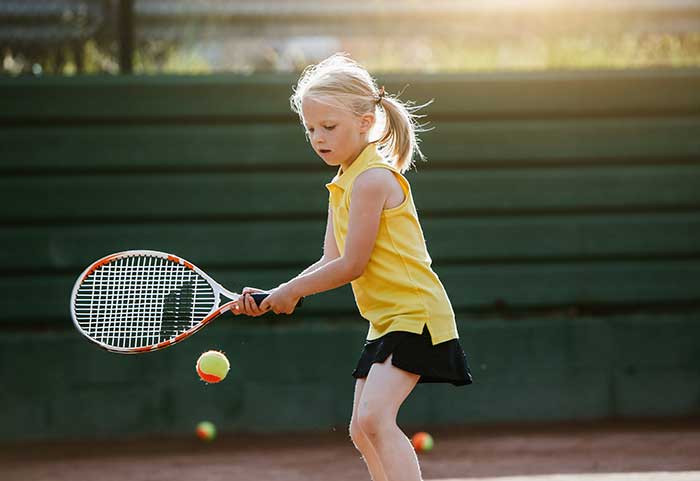 Kind beim Tennisspielen